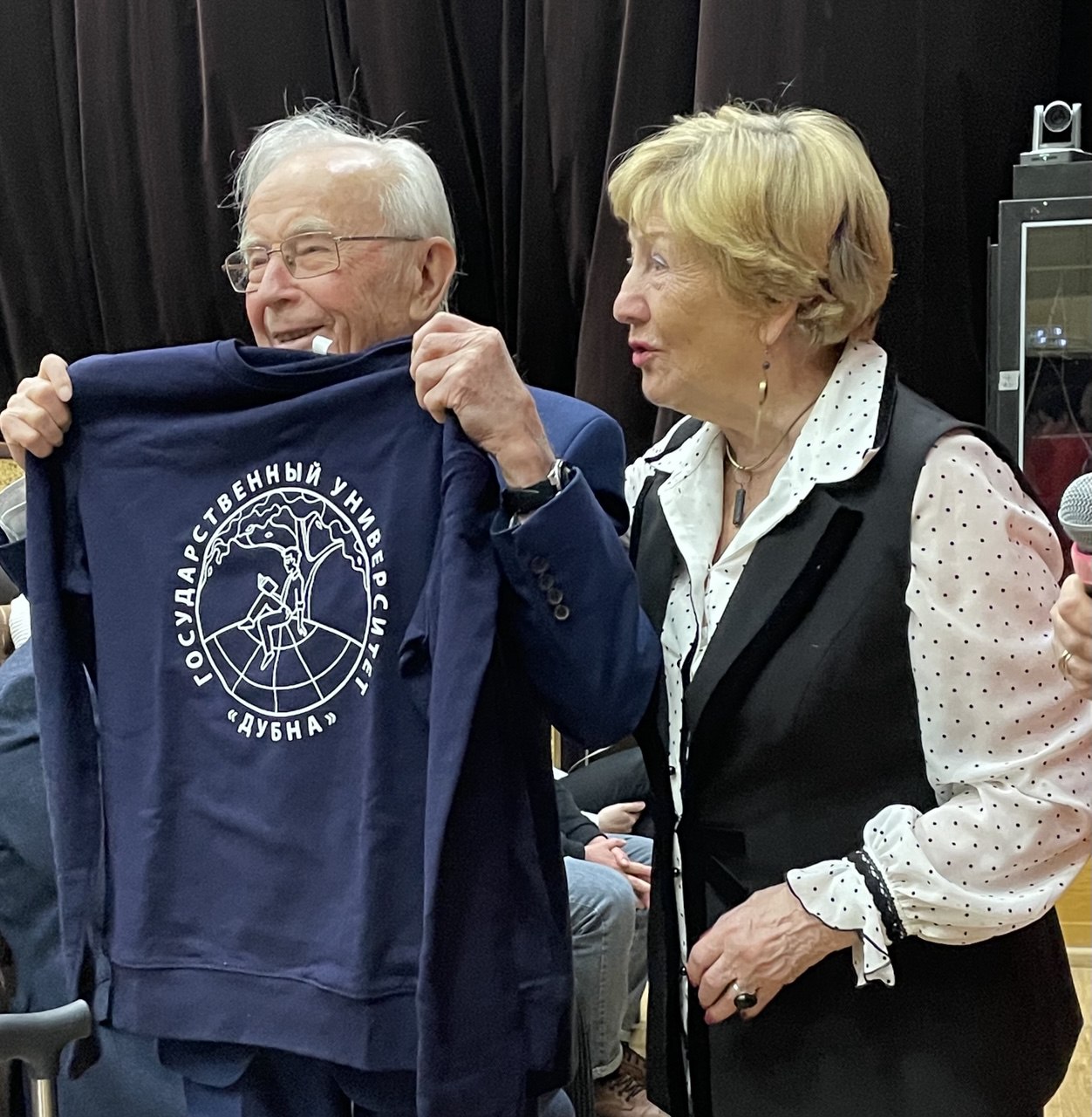 Научный руководитель ИСАУ Евгения Черемисина вручает Геннадию Ососкову толстовку с логотипом ГУД